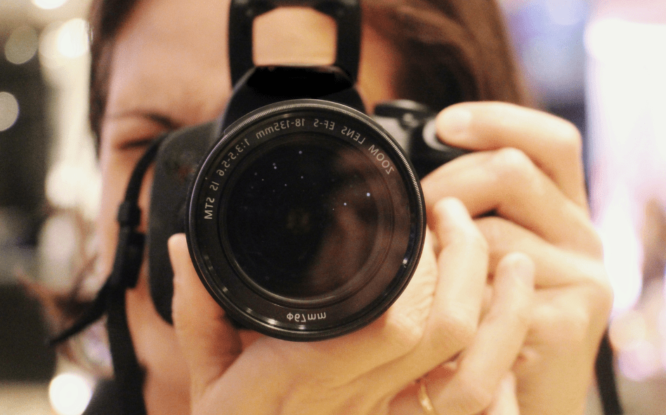 कैमरे से फोटो खींचती महिला