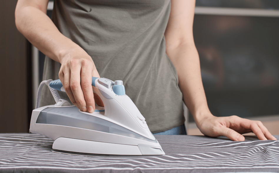 a person ironing a shirt - Steam iron vs dry iron