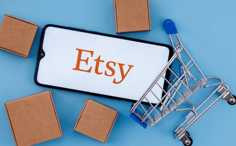 an image displaying etsy shopping logo with few boxes and cart around 